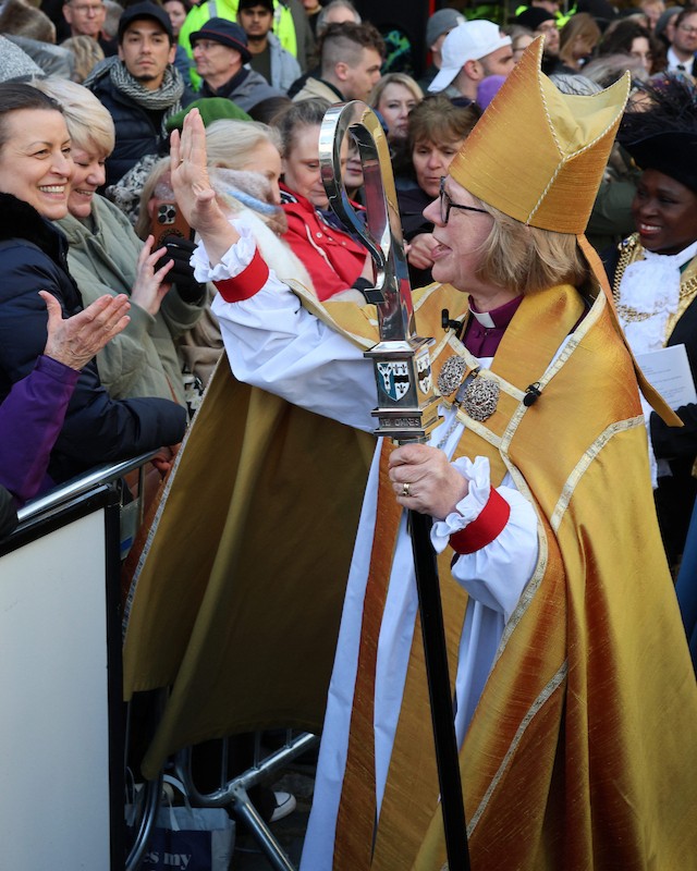 An African choir dressed in vibrant Kente-patterned attire performing during Dame Sarah Mullally's installation at Canterbury Cathedral.