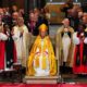 Dame Sarah Mullally seated on the Archbishop's throne in Canterbury Cathedral surrounded by clergy.