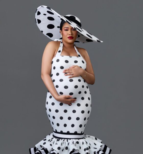 Anna Ebiere Banner in a black and white polka-dot halter gown with a matching oversized disc hat, showcasing her baby bump.