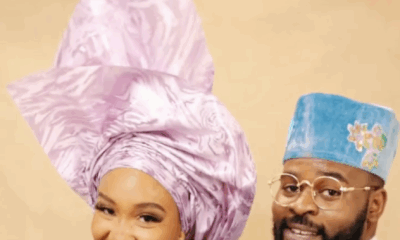 Falz in a turquoise floral Agbada and a model in a purple lace buba and lilac Gele posing together.