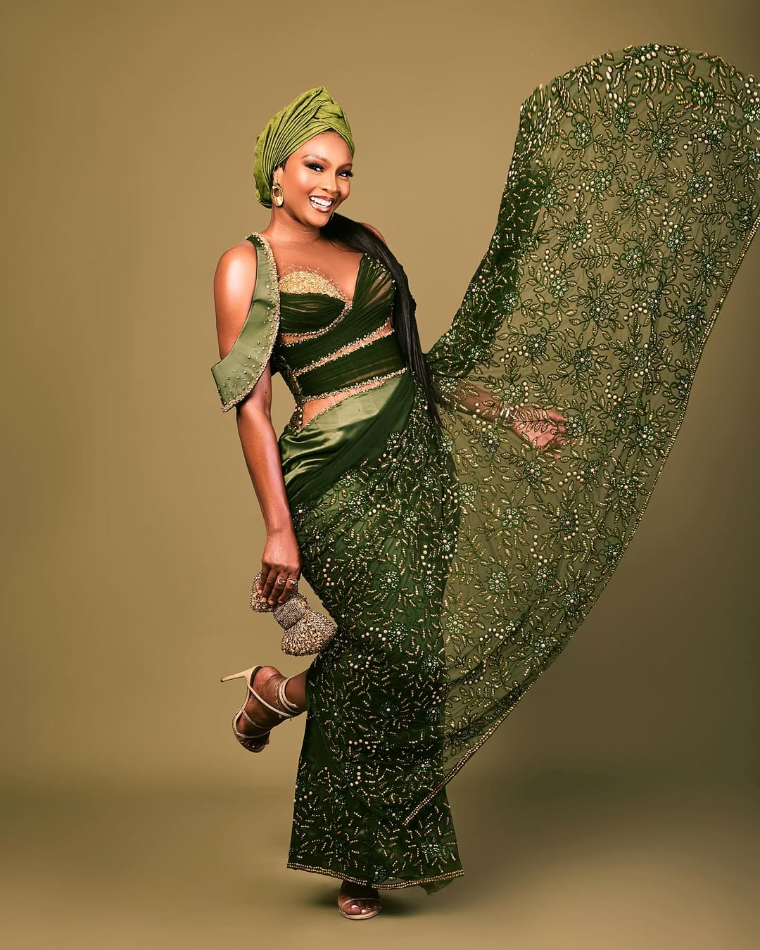 Osas Ighodaro in a forest green draped Veekee James gown with gold beaded detailing and matching headwrap for the #LoveUnbeaten24 wedding in Lagos.