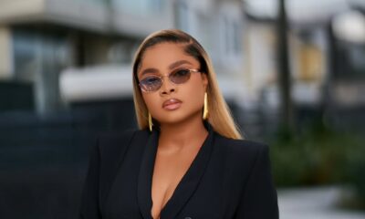 Bimbo Ademoye wearing a black blazer and tinted sunglasses in a professional outdoor portrait.