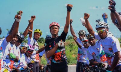 Kanyeyachukwu Tagbo-Okeke and a group of Nigerian cyclists raising their fists in a power salute for autism awareness.