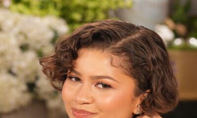 A close-up of Zendaya smiling during her interview on The Jennifer Hudson Show, wearing a structured white peplum top with fur trim.