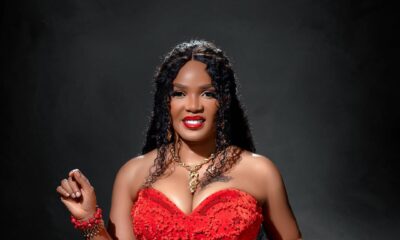 Close-up of Iyabo Ojo wearing a strapless red gown by Medlin Couture, styled with layered gold necklaces and a matching red clutch.