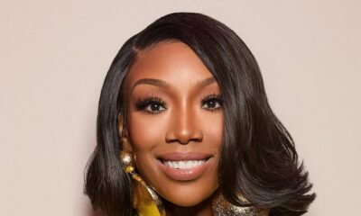 Close-up portrait of Brandy’s beauty look for The Jennifer Hudson Show, featuring a sleek chin-length bob with flicked ends and massive hammered-gold disc earrings.