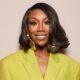 Close-up portrait of Brandy’s beauty look for The Jennifer Hudson Show, featuring a sleek chin-length bob with flicked ends and massive hammered-gold disc earrings.