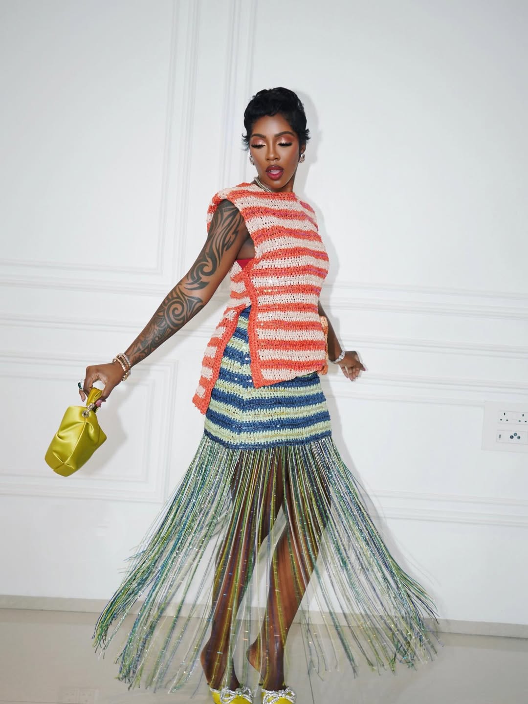 Side profile of Tiwa Savage at the Tiwa Savage Music Foundation’s Berklee in Nigeria event, featuring Lisa Folawiyo Studio craftsmanship and a ruched yellow bag.