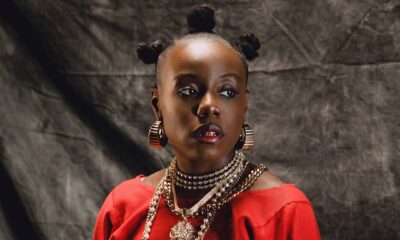 Close-up of Teni-the-Entertainer in red-clothing featuring layered-gold-necklaces and Bantu-knots hairstyle.