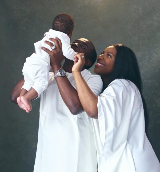Theophilus Sunday and Ashlee Sunday holding their son Mystery during a family photo session in all-white outfits.