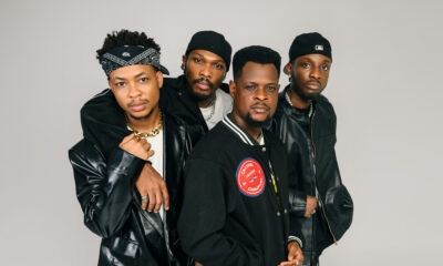 A tight group studio portrait of Nollywood stars Mike Afolarin, Chimezie Imo, Emeka Nwagbaraocha, and Tomiwa Tegbe looking directly into the camera in coordinated black jackets and streetwear.