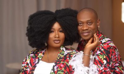 Lateef Adedimeji and Adebimpe wearing matching vibrant patterned robes with white feather trim.