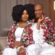 Lateef Adedimeji and Adebimpe wearing matching vibrant patterned robes with white feather trim.