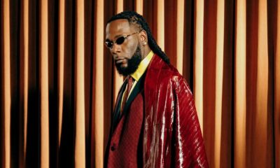 Burna Boy wearing a custom burgundy suit and leather cape by Ozwald Boateng at the 2025 Met Gala.