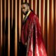 Burna Boy wearing a custom burgundy suit and leather cape by Ozwald Boateng at the 2025 Met Gala.