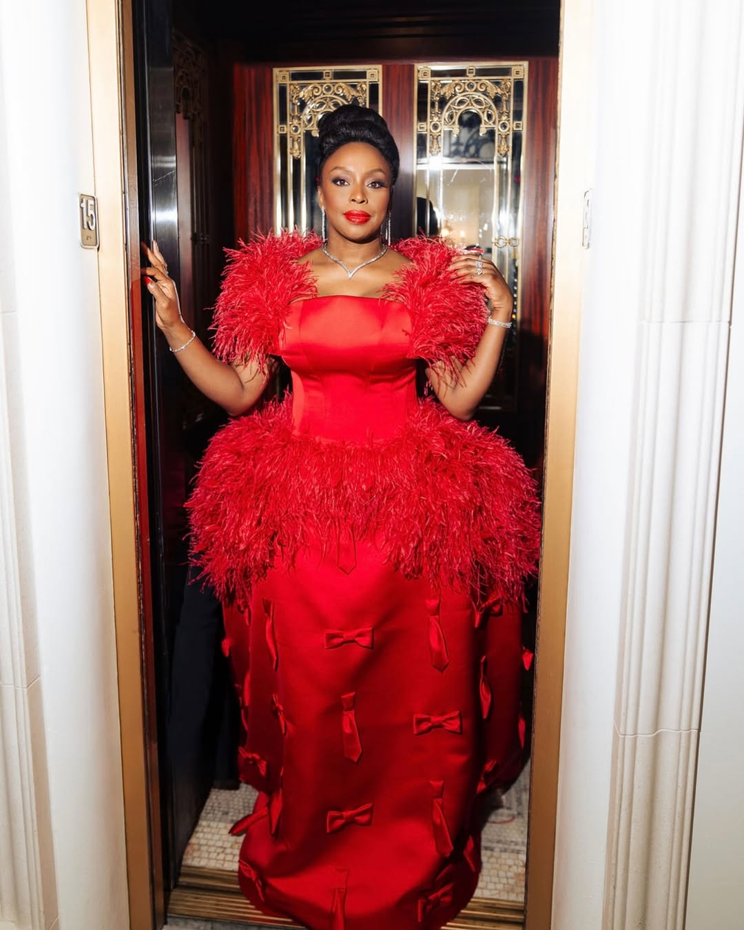 Chimamanda Ngozi Adichie in a crimson couture gown by Prabal Gurung for the 2025 Met Gala "Superfine: Tailoring Black Style" theme.
