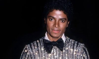An archival photo of Michael Jackson wearing a black and silver sequined suit with a bow tie, representing his peak era as a global digital artist.