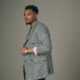 American gospel singer Jonathan McReynolds posing in a black and white houndstooth double-breasted blazer for his appearance on The Jennifer Hudson Show.