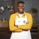 Olaolu Olorunnimbe wearing the official MasterChef Australia 2026 white apron after securing his place in the Top 24 competition.