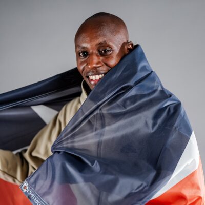 Sabastian Sawe draped in the Kenyan flag following his record-breaking sub-two-hour marathon performance in London.