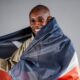 Sabastian Sawe draped in the Kenyan flag following his record-breaking sub-two-hour marathon performance in London.