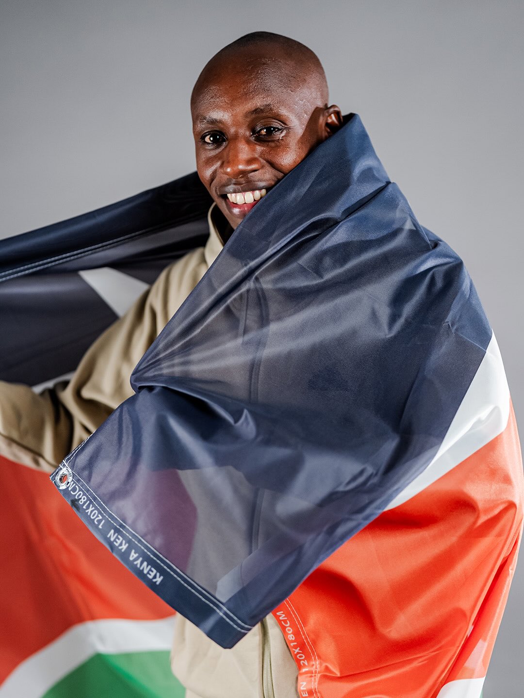 Sabastian Sawe draped in the Kenyan flag following his record-breaking sub-two-hour marathon performance in London.