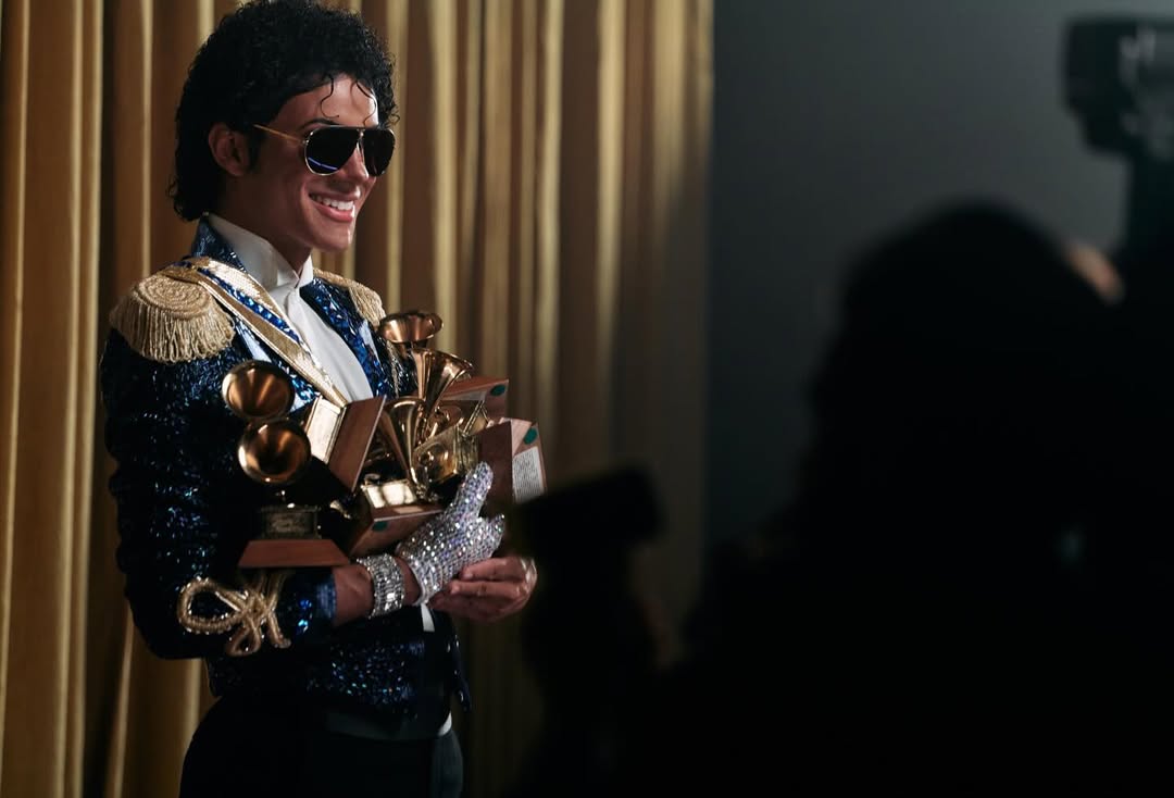 aafar Jackson in a blue military-style sequined jacket holding Michael Jackson's actual Grammy Awards on the set of the 2026 biopic.