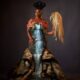 Bisola Aiyeola at the AMVCA 12 Cultural Night wearing an Igbo-inspired "Mmiri Ndu" waterfall gown and holding a traditional horsetail.