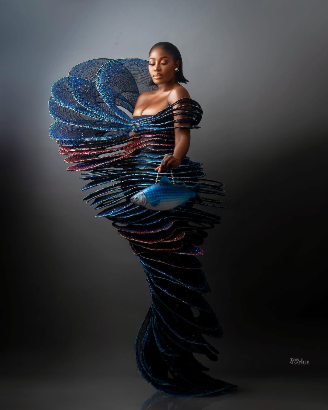 Nana Akua Addo wearing the aquatic-inspired spiral dress by Srushti Patil with a fish-shaped handbag.