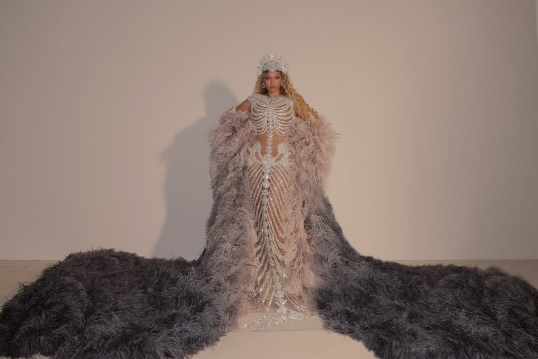 Beyoncé wearing a custom Olivier Rousteing silver skeleton gown with a spiked headpiece and feather train at Met Gala 2026.