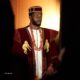Bucci Franklin in a wine velvet cultural ensemble designed by Amy Aghomi featuring gold monkey motifs and coral beads for the AMVCA 12 Cultural Night.