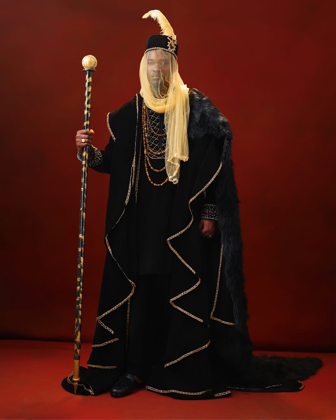 Jason Jae in a black velvet Northern-style robe with a gold face veil and Zanna cap for the AMVCA 12 Cultural Night.