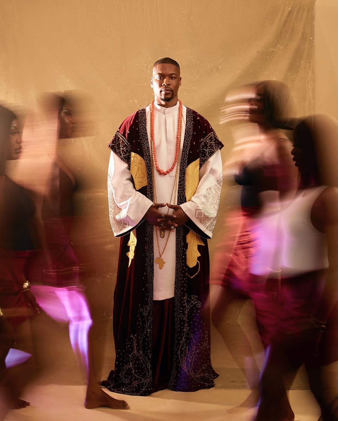 Shaun in a wine velvet Edo-style robe and white tunic with coral beads for the AMVCA 12 Cultural Night.