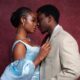 Uzoamaka Power and Andrew Bunting posing closely together in coordinated blue outfits at the Call of My Life premiere.
