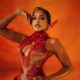 Close-up of Uche Montana’s fire-inspired AMVCA 2026 look, highlighting the red-studded hand wraps and gold-tipped feathers.
