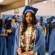 Lilo Aderogba standing in her academic gown among fellow graduates during a commencement ceremony.