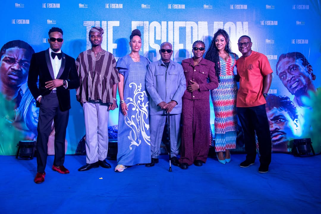 Director Zoey Martinson and the cast of the Ghanaian comedy adventure film The Fisherman posing together on the blue carpet at the movie's official Lagos premiere.