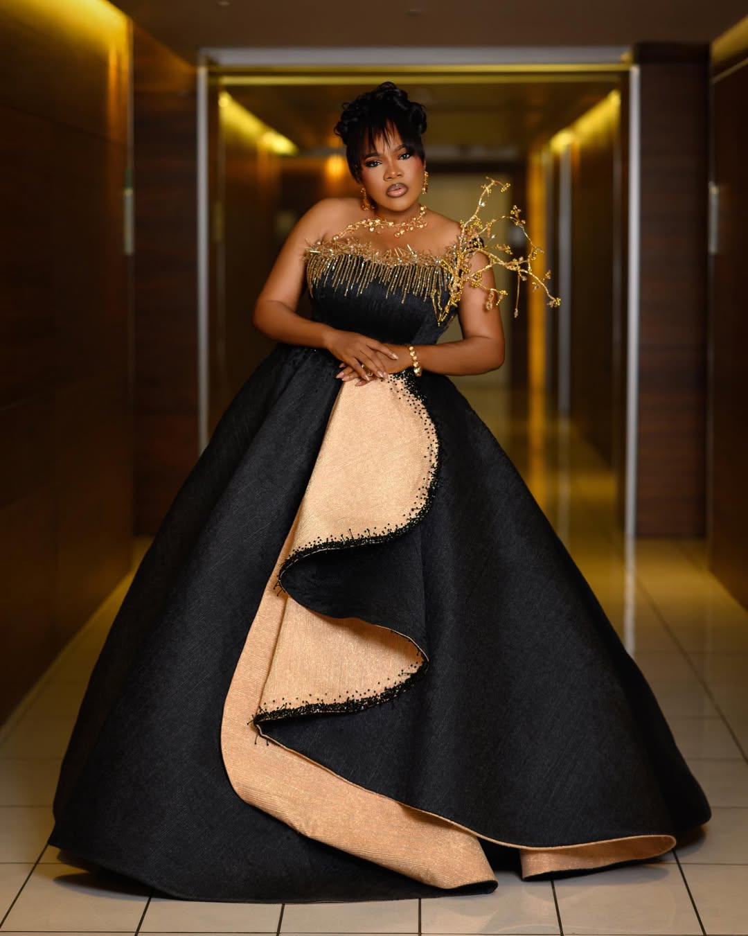 Nollywood actress Toyin Abraham in a structured strapless black and champagne gold ballgown by Prudent Gabriel of Prudential at the AMVCA 2026 awards ceremony.