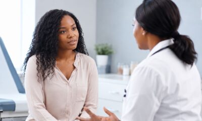 AI-generated illustration of a young woman and a doctor discussing a brochure about the transition from PCOS to Polyendocrine Metabolic Ovarian Syndrome (PMOS).