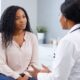AI-generated illustration of a young woman and a doctor discussing a brochure about the transition from PCOS to Polyendocrine Metabolic Ovarian Syndrome (PMOS).