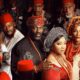 Movie poster for ‘The Serpent’s Gift’ featuring Linda Ejiofor, Stan Nze, Tina Mba, and Daniel Etim Effiong in traditional Igbo attire including red caps and coral beads.