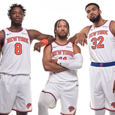 New York Knicks players OG Anunoby, Jalen Brunson, and Karl-Anthony Towns posing together in their white home jerseys.