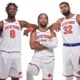 New York Knicks players OG Anunoby, Jalen Brunson, and Karl-Anthony Towns posing together in their white home jerseys.
