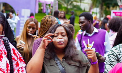 Shoppers queue under umbrellas in the rain at Beguile's Summer Has a Scent pop-up in Abuja
