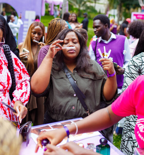 Shoppers queue under umbrellas in the rain at Beguile's Summer Has a Scent pop-up in Abuja