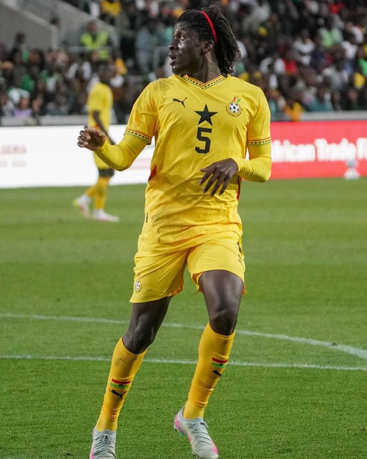 Ghanaian midfielder Caleb Yirenkyi playing on the pitch in a yellow jersey with number 5 during his senior debut for the Ghana Black Stars.