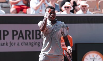 A close-up of young tennis prodigy Moise Kouame clenching his fist in celebration on court during his first-round match at the 2026 French Open.