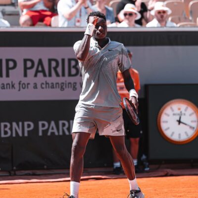 A close-up of young tennis prodigy Moise Kouame clenching his fist in celebration on court during his first-round match at the 2026 French Open.