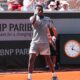 A close-up of young tennis prodigy Moise Kouame clenching his fist in celebration on court during his first-round match at the 2026 French Open.