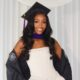 Chioma Amadi smiling in a white strapless dress with her black Savannah College of Art and Design graduation gown draped loosely over her arms.